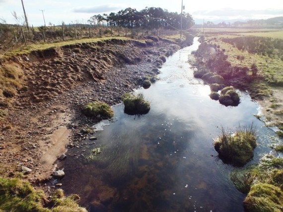 The view downstream from below the road bridge. This shot was taken in winter but the bare banks and erosion have gone.